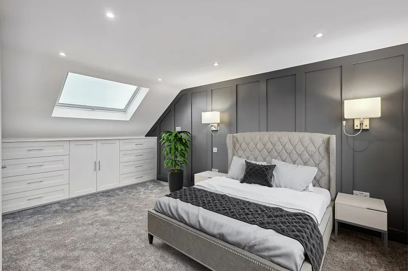 a bedroom with a large bed and a skylight