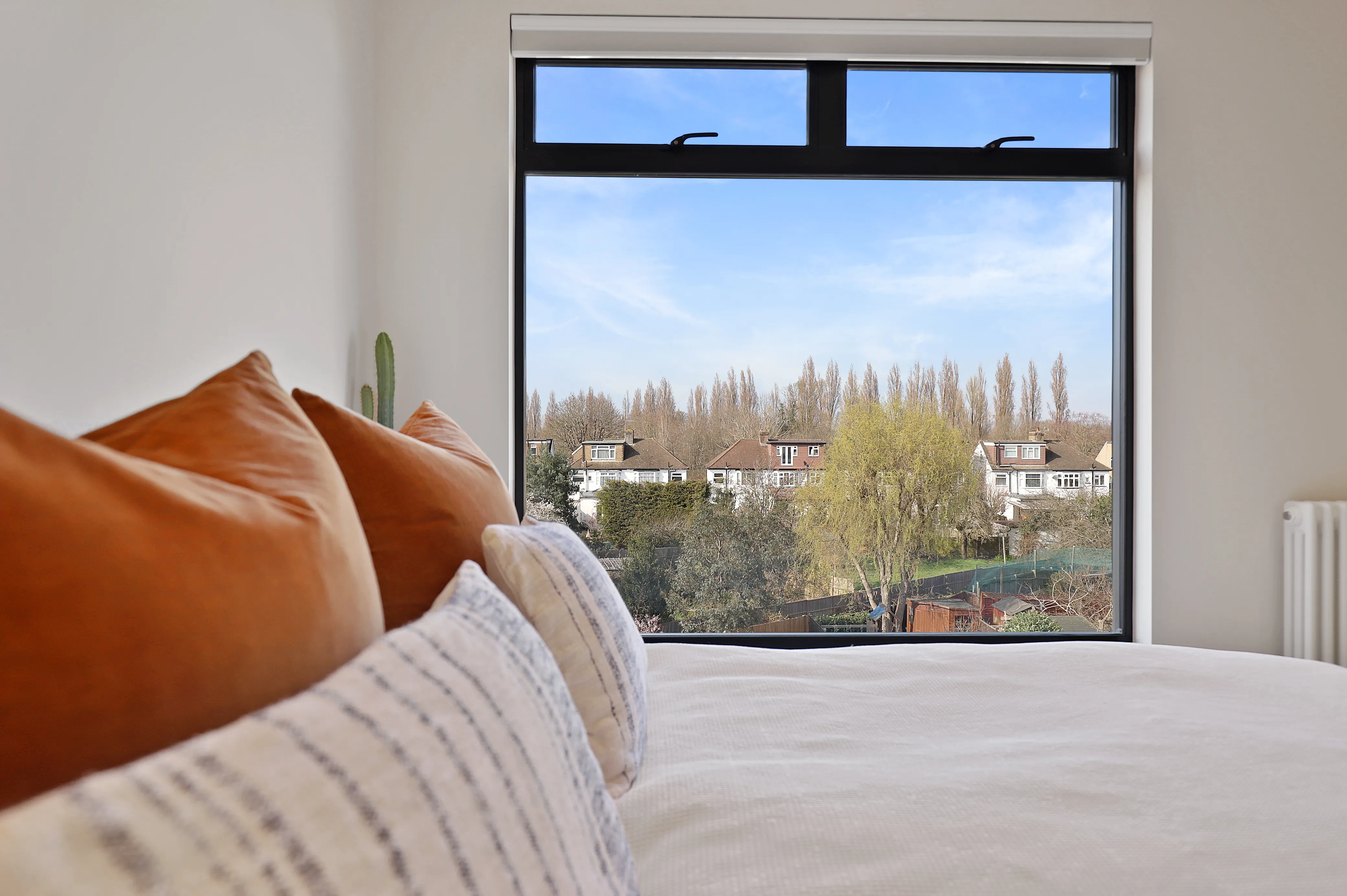 a bedroom with a large window overlooking a city