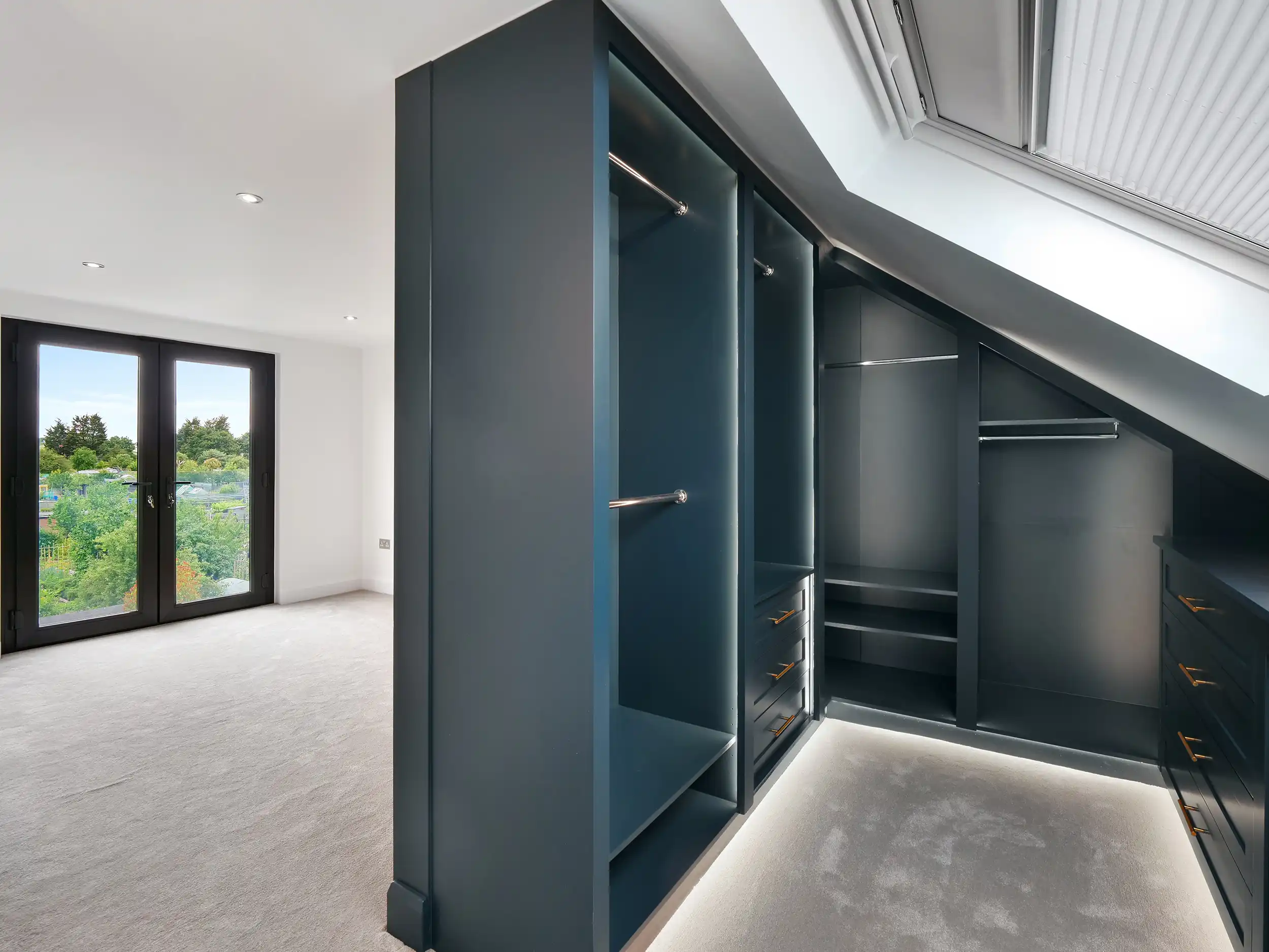 A room with a closet and a large window.